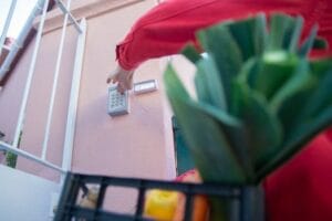 InterfonosInteligente.com Close-up of a person using a security keypad on a gate, highlighting home access control.